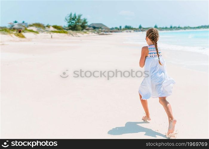 Adorable little girl at tropical beach on vacation. Adorable little girl have fun at tropical beach during vacation