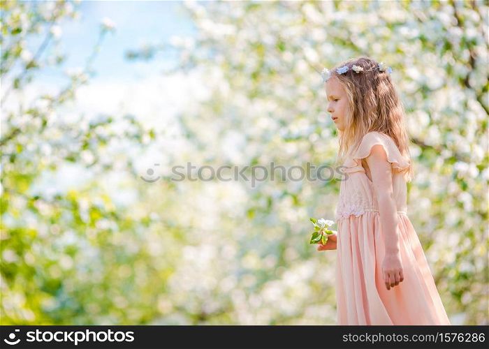 Adorable little girl in blooming apple tree garden on spring day. Adorable little girl in blooming apple garden on beautiful spring day