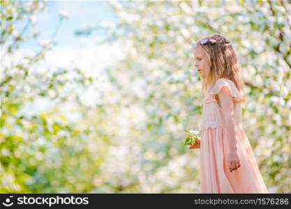Adorable little girl in blooming apple tree garden on spring day. Adorable little girl in blooming apple garden on beautiful spring day