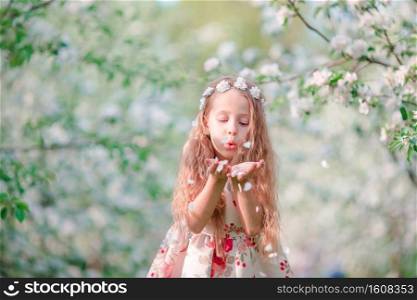 Adorable little girl in blooming cherry garden on beautiful spring day. Adorable little girl in blooming cherry tree garden on spring day