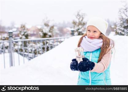 Adorable little girl in frozen winter day outdoors playi with snow. Adorable little girl in frozen winter day outdoors