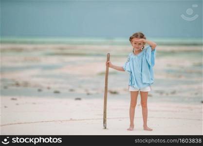 Adorable little girl on the beach in low tide in Zanzibar. Cute little girl at beach during summer vacation