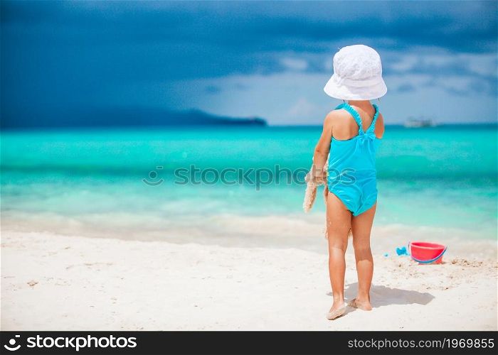 Adorable little girl playing with toys on beach vacation. Adorable little girl playing with beach toys on white tropial beach