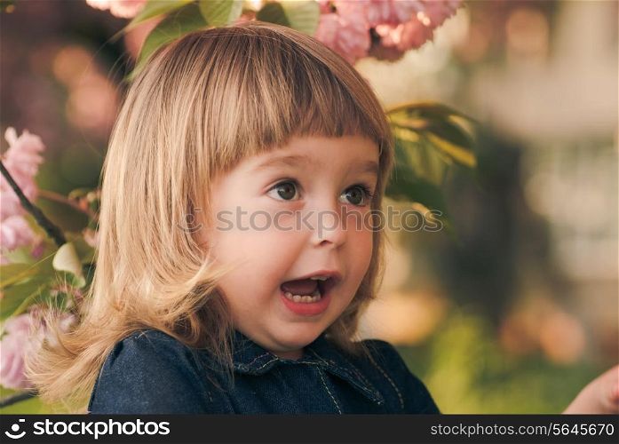 Adorable little girl&rsquo;s portrait in the garden, sakura blossom