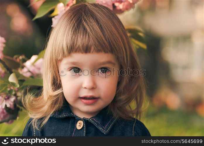 Adorable little girl&rsquo;s portrait in the garden, sakura blossom