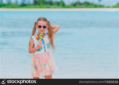 Adorable little girl with candie on white beach. Adorable little girl with lollipop on tropical beach