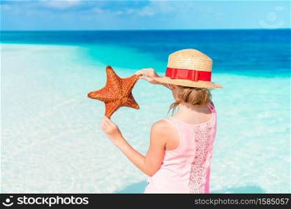 Adorable little girl with starfish on the beach. Adorable little girl with starfish on white empty beach