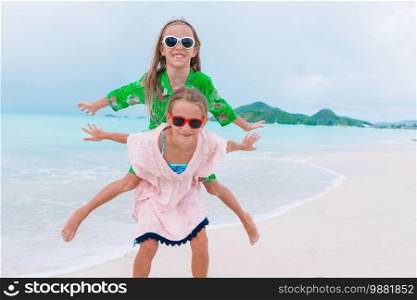Adorable little girls have fun on the beach. Happy kids running and jumping at beach