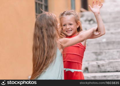 Adorable little girls in the city having fun. Adorable fashion little girls outdoors in European city