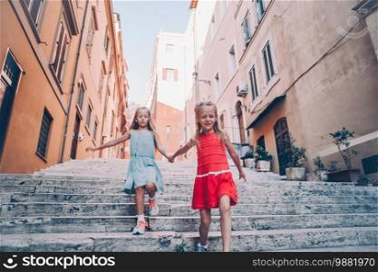 Adorable little girls on vacation in Italy running and having fun outdoors. Adorable fashion little girls outdoors in European city