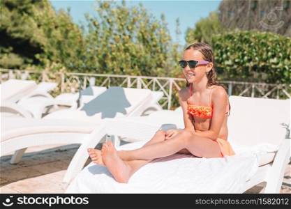 Adorable little kid on lounger relax near swimming pool. Adorable little kid on lounger at beach during summer vacation