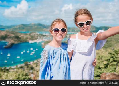 Adorable little kids enjoying the view of picturesque English Harbour at Antigua in caribbean sea. View of paradise bay at tropical island in the Caribbean Sea. Adorable little kids enjoying the view of picturesque English Harbour at Antigua in caribbean sea