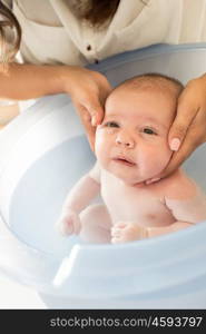 Adorable newborn baby having a bath by the mother