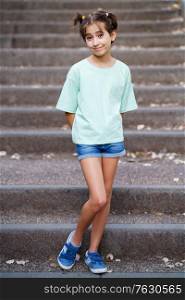 Adorable Nine-year-old girl standing on the steps of a city park.. Nine-year-old girl standing on the steps outdoors