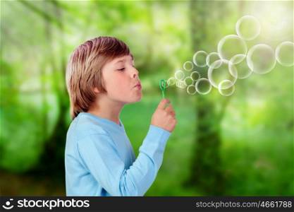 Adorable preteen boy blowing for make bubbles in the park