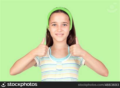 Adorable preteen girl accepting with the tumbs on green background