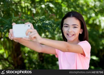 Adorable preteen girl with mobile with plants of background