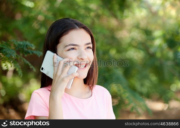 Adorable preteen girl with mobile with plants of background