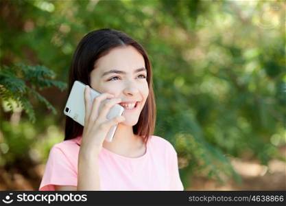 Adorable preteen girl with mobile with plants of background
