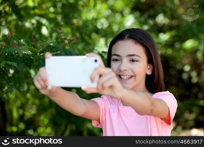 Adorable preteen girl with mobile with plants of background