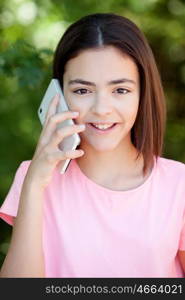 Adorable preteen girl with mobile with plants of background