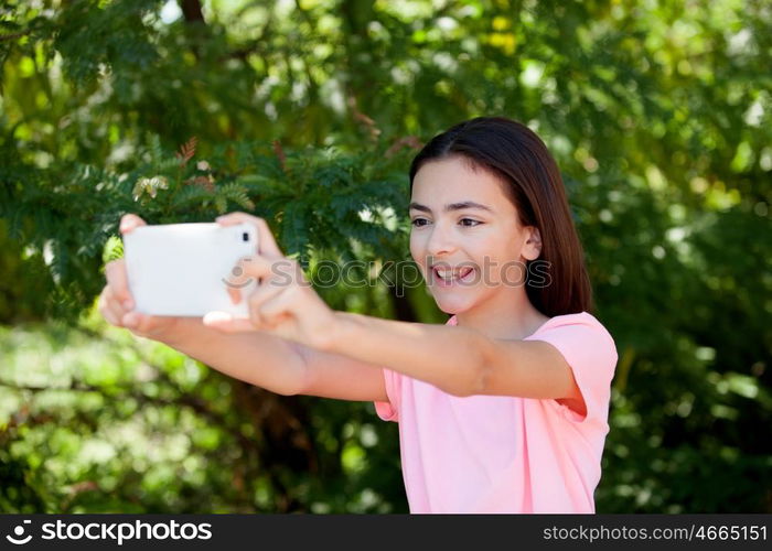 Adorable preteen girl with mobile with plants of background