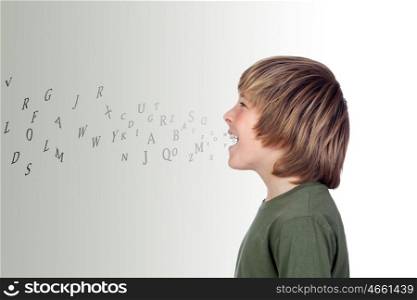 Adorable preteen with many letters out of his mouth isolated on a over grey background
