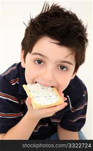 Adorable six year old boy eating a frosted toaster pastry.