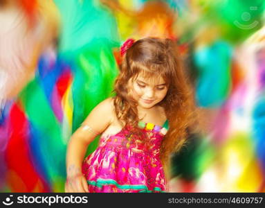 Adorable small girl dancing over blur colors background, three-year birthday girl, little happy kid enjoying child party outdoors, children playful activities, colorful decoration, carnival concept