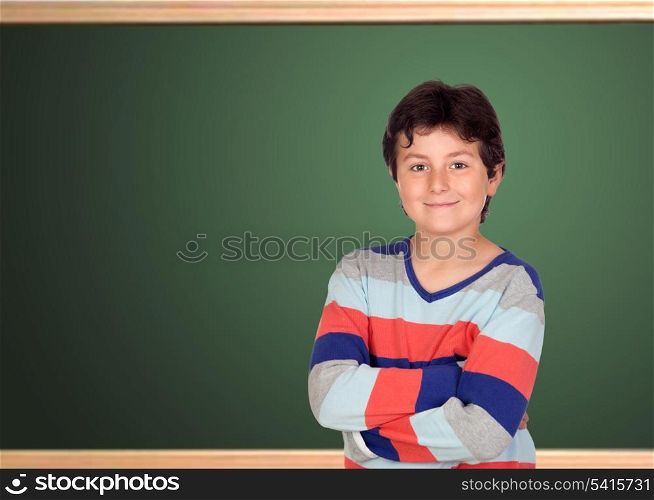 Adorable student at school in front of a blackboard