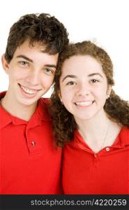 Adorable teen couple in red polo shirts against a white background.