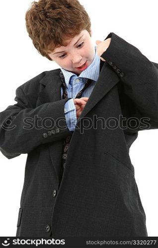 Adorable ten year old american boy in baggy blue suit looking in jacket pocket over white background.