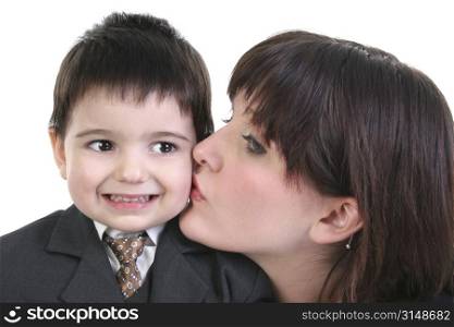 Adorable toddler boy in suit getting kiss on cheek from beautiful young woman.