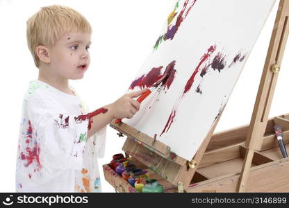 Adorable Toddler Boy Painting at Easel. Shot in studio over white.