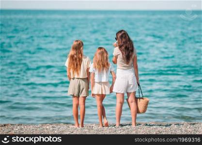 Adorable with mother on the beach. Adorable little girls and young mother on tropical white beach