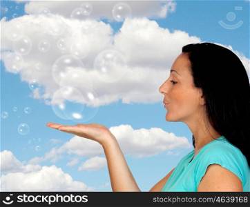 Adorable woman blowing bubbles with a blue sky of background