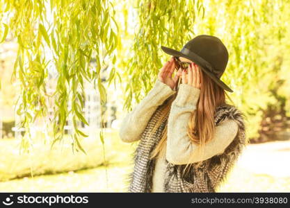 Adorable woman in sunglasses. Beauty and fashion of women. Young attractive fashionable girl wearing stylish hat waistcoat and sunglasses. Pretty woman around leaves of willow tree.