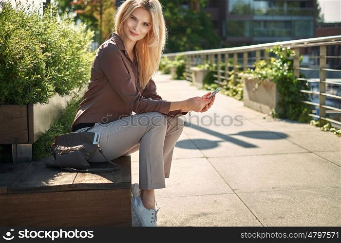 Adorable woman sitting on the wooden public bench