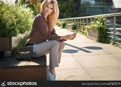 Adorable woman sitting on the wooden public bench