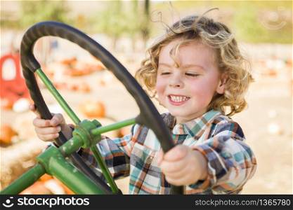 Adorable Young Boy Playing on an Old Tractor in a Rustic Outdoor Fall Setting.