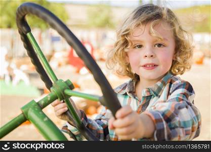Adorable Young Boy Playing on an Old Tractor in a Rustic Outdoor Fall Setting.