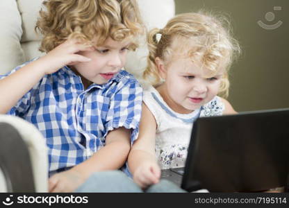 Adorable Young Brother and Sister Using Their Computer Laptop Together.