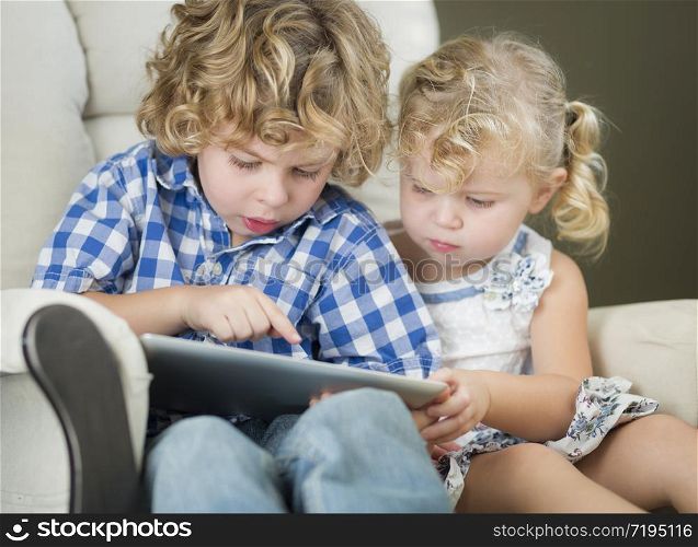 Adorable Young Brother and Sister Using Their Computer Tablet Together.