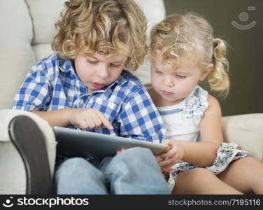 Adorable Young Brother and Sister Using Their Computer Tablet Together.