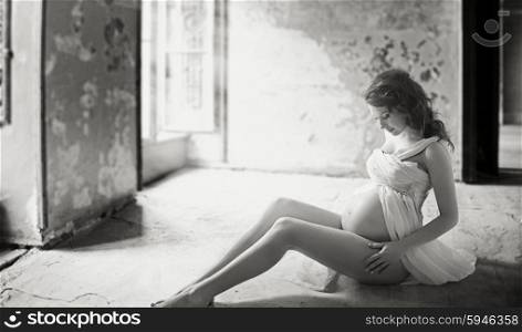 Adorable young pregnant mother in ancient building