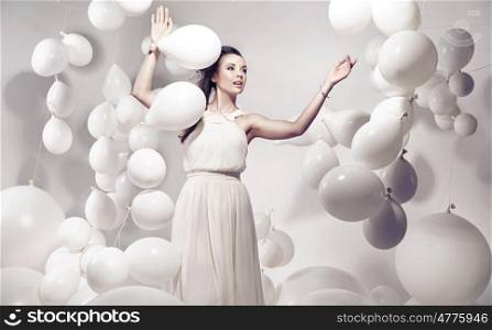 Adorable young woman holding many white balloons