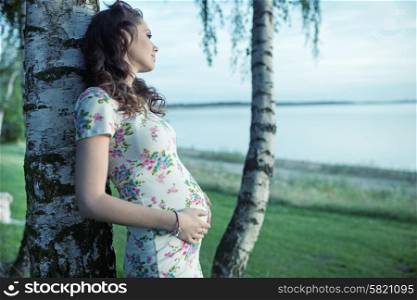 Adorbale pregnant lady touching her belly