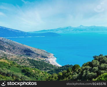 Adriatic sea summer coast with beach and Corfu island in mist, Lukove komuna, Albania. View from mountain pass.