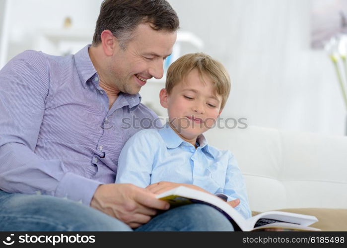 Adult and child laughing at book