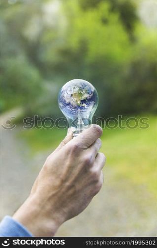 adult arm keeping lamp with planet
